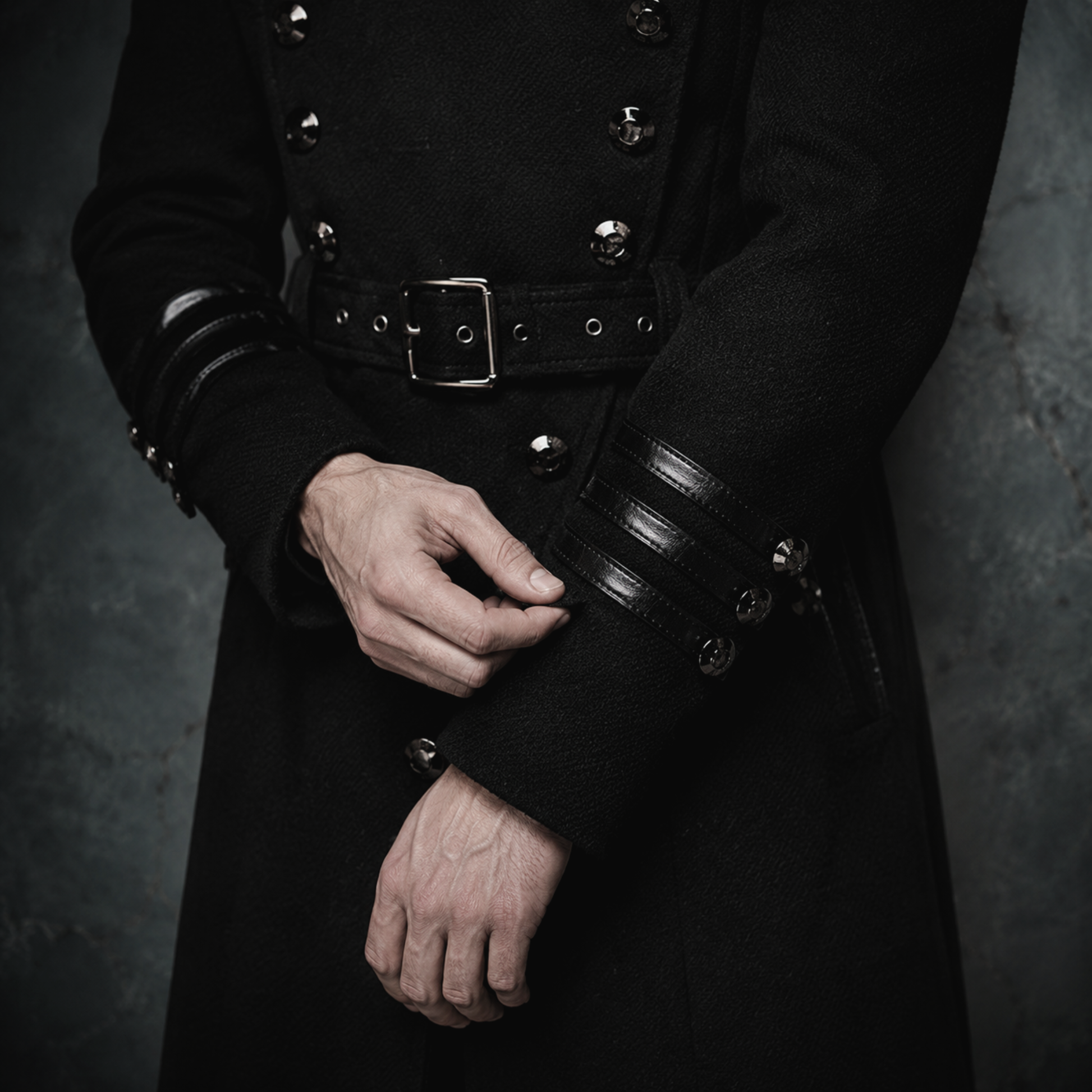 Man wearing black gothic military long coat with double breasted metal buttons and structured high collar