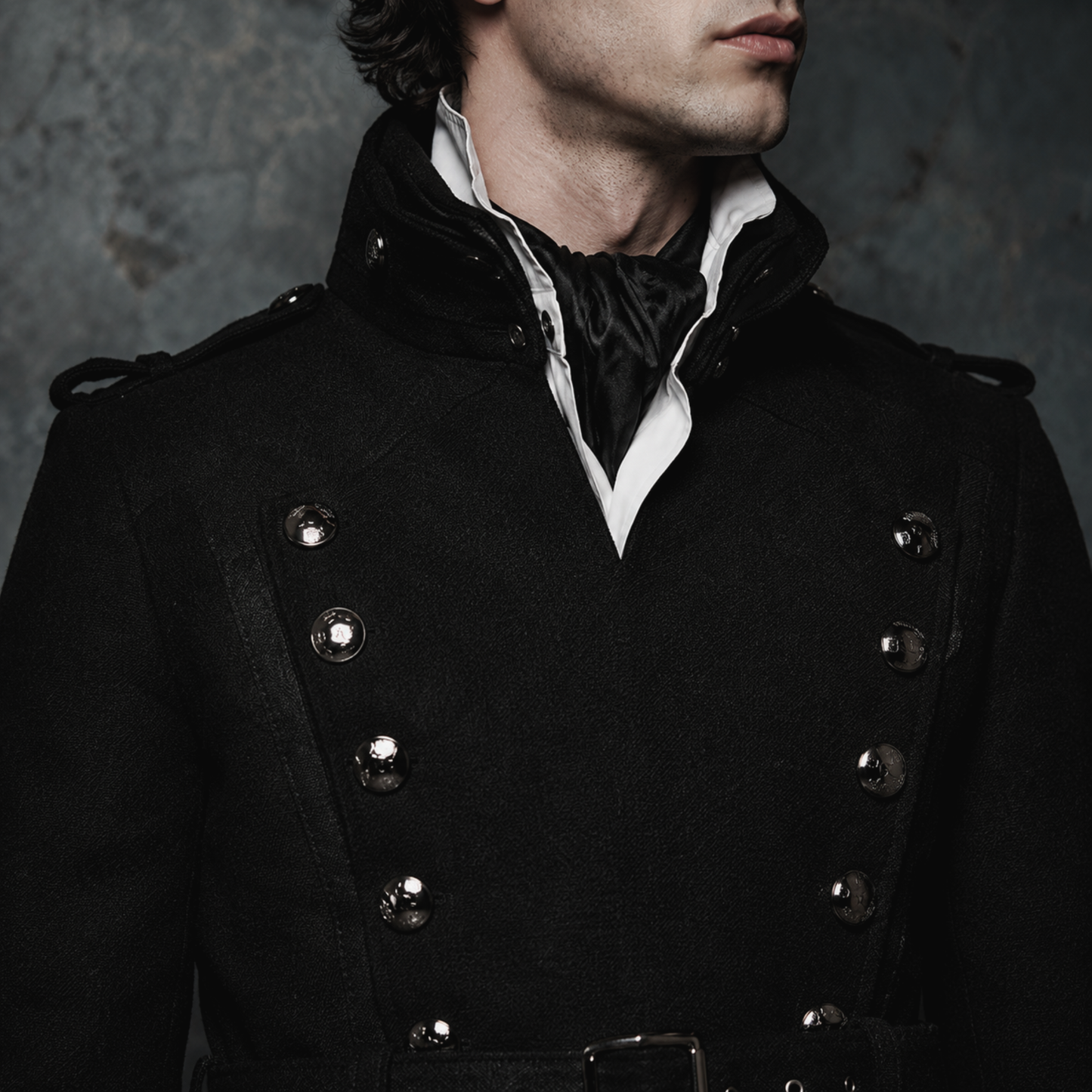 Man wearing black gothic military long coat with double breasted metal buttons and structured high collar