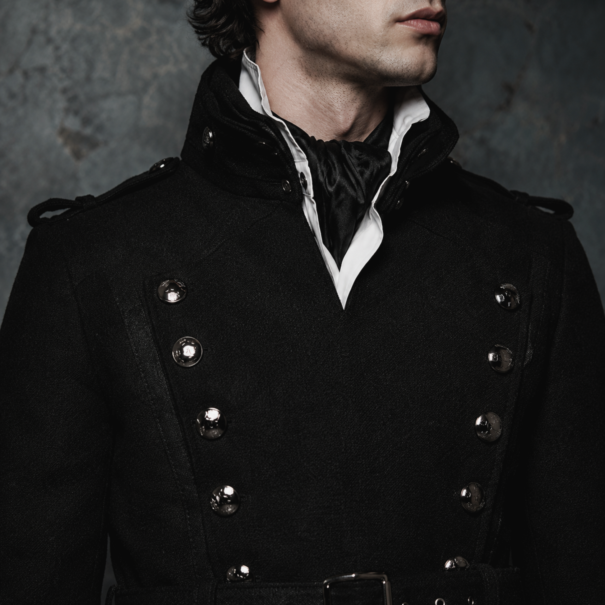 Man wearing black gothic military long coat with double breasted metal buttons and structured high collar