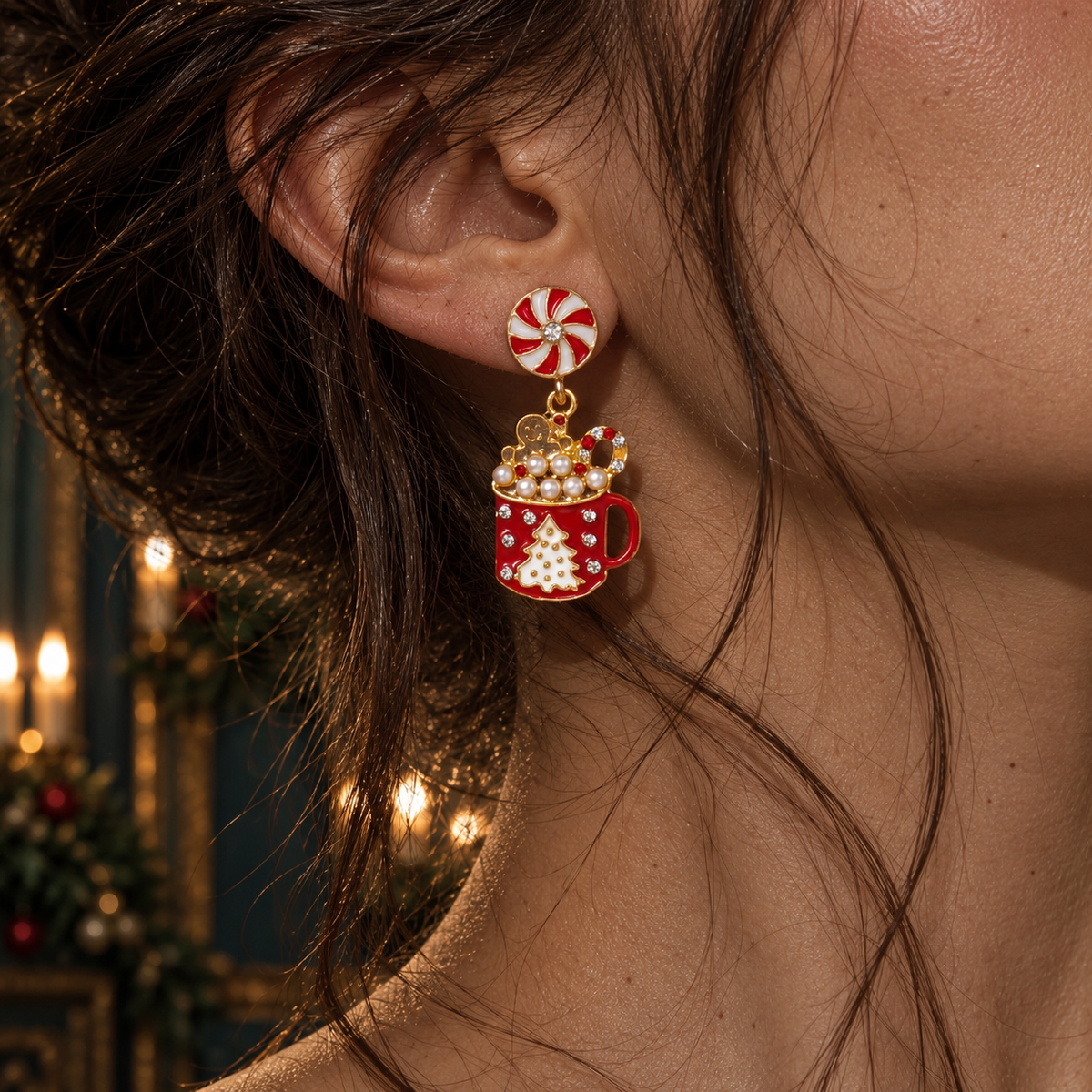 A close-up of a person's ear wearing a festive holiday dangle earring. The earring features a red and white peppermint candy top with a gold-tone chain and a red stocking charm decorated with white snowflakes and topped with a small gold ornament.