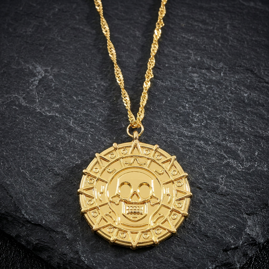 Gold necklace with a skull and crossbones pendant on a white background