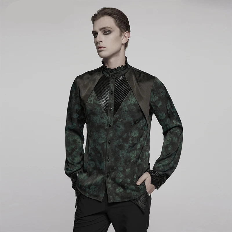 A man modeling a dark green and black patterned gothic long-sleeve shirt with contrasting black satin shoulder panels and a pleated high collar, set against a plain light gray background.