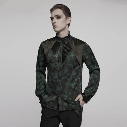 A man modeling a dark green and black patterned gothic long-sleeve shirt with contrasting black satin shoulder panels and a pleated high collar, set against a plain light gray background.
